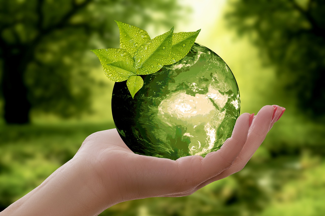Woman holding a glass globe outside by trees